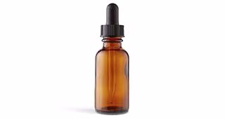 Amber glass dropper bottle with black cap and pipette, isolated on white background