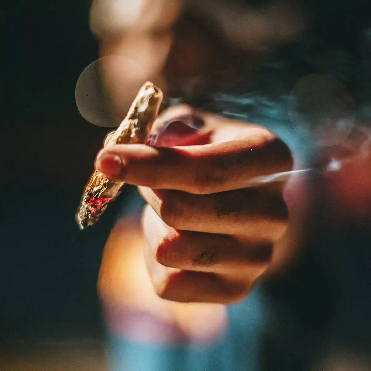 Hand Holding a Lit Marijuana Joint