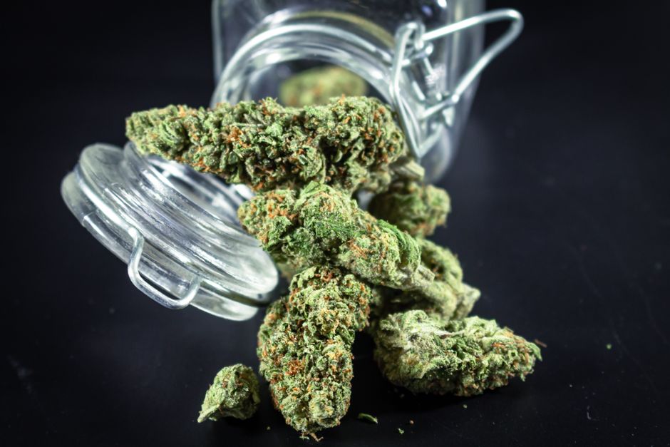 Cannabis buds spilling from glass jar