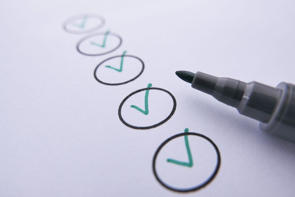 Checklist with green check marks and marker