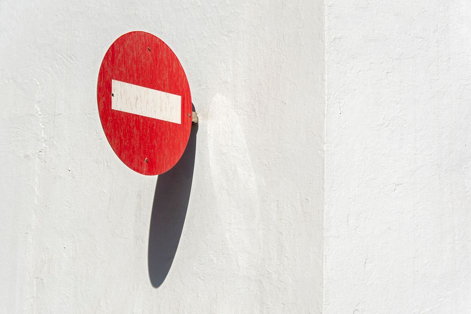Red no entry traffic sign on white wall