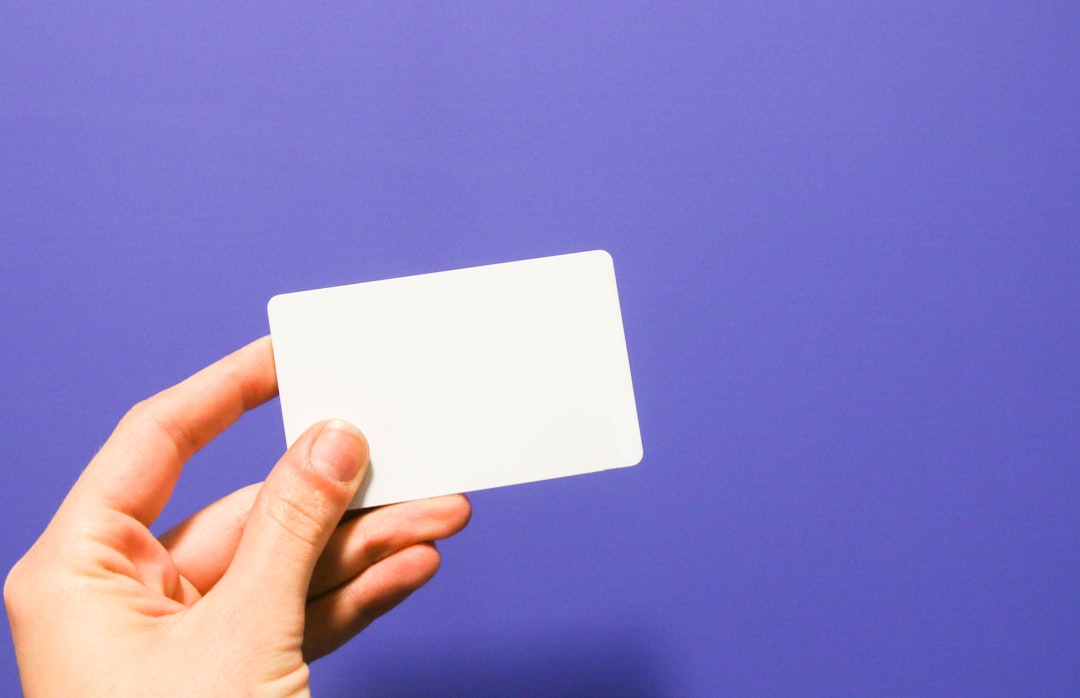 blank card being held in front of purple background