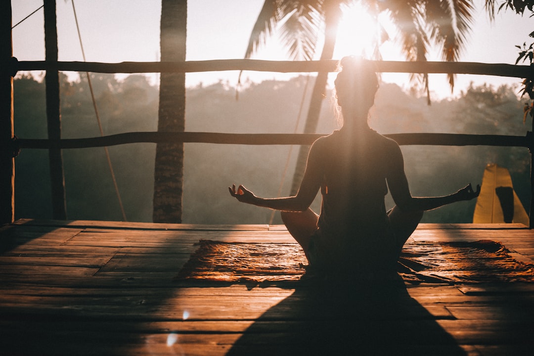 sillouette of woman meditating on a deck