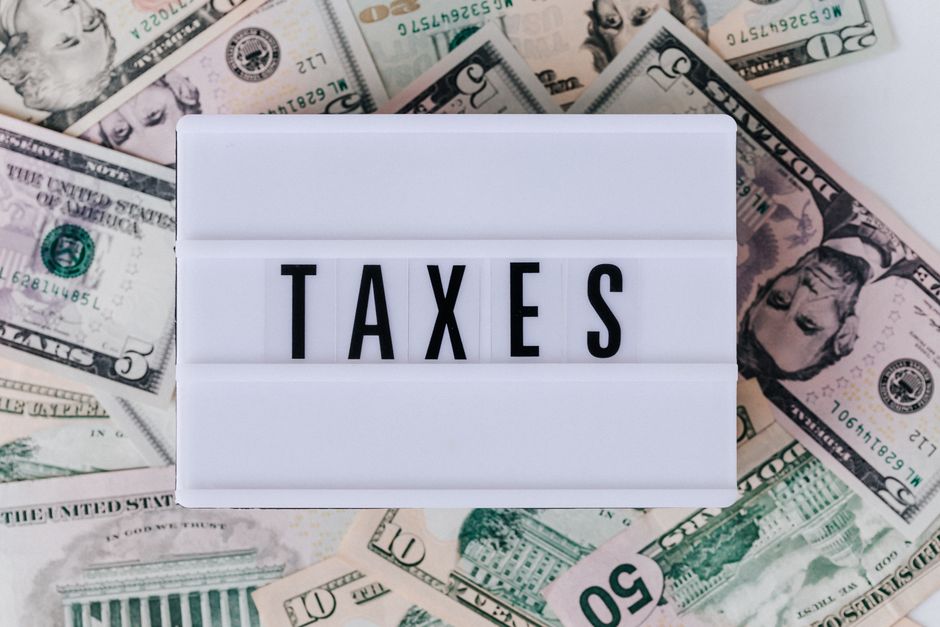 taxes on a small sign on top of money
